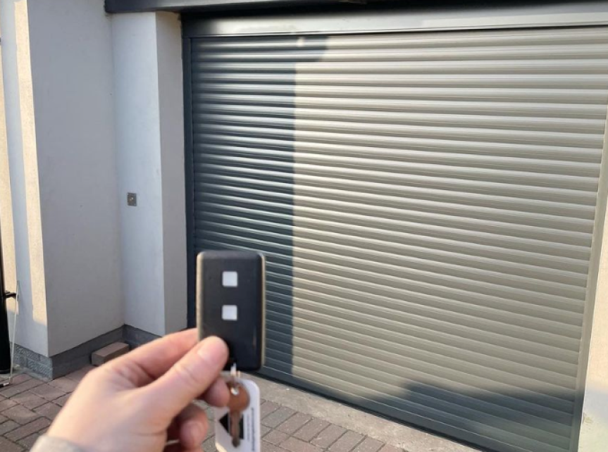 Electric roller garage door in anthracite grey with remote key fob.