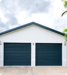 Anthracite grey roller doors on a rendered garage.